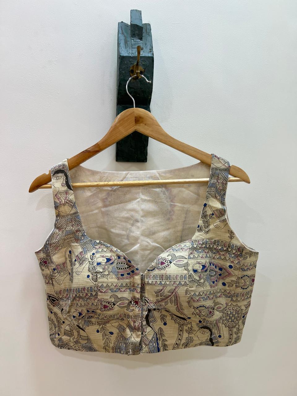 Patterned bralette on a wooden hanger against a white background